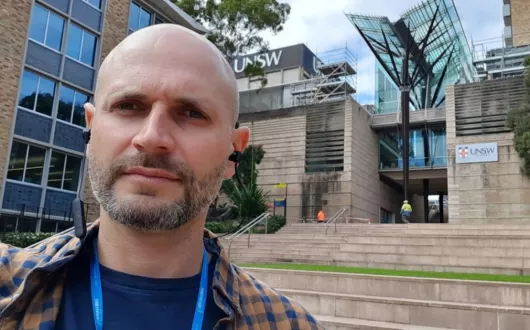 Dr inż. Daniel Jodko w Sydney przed budynkiem UNSW.